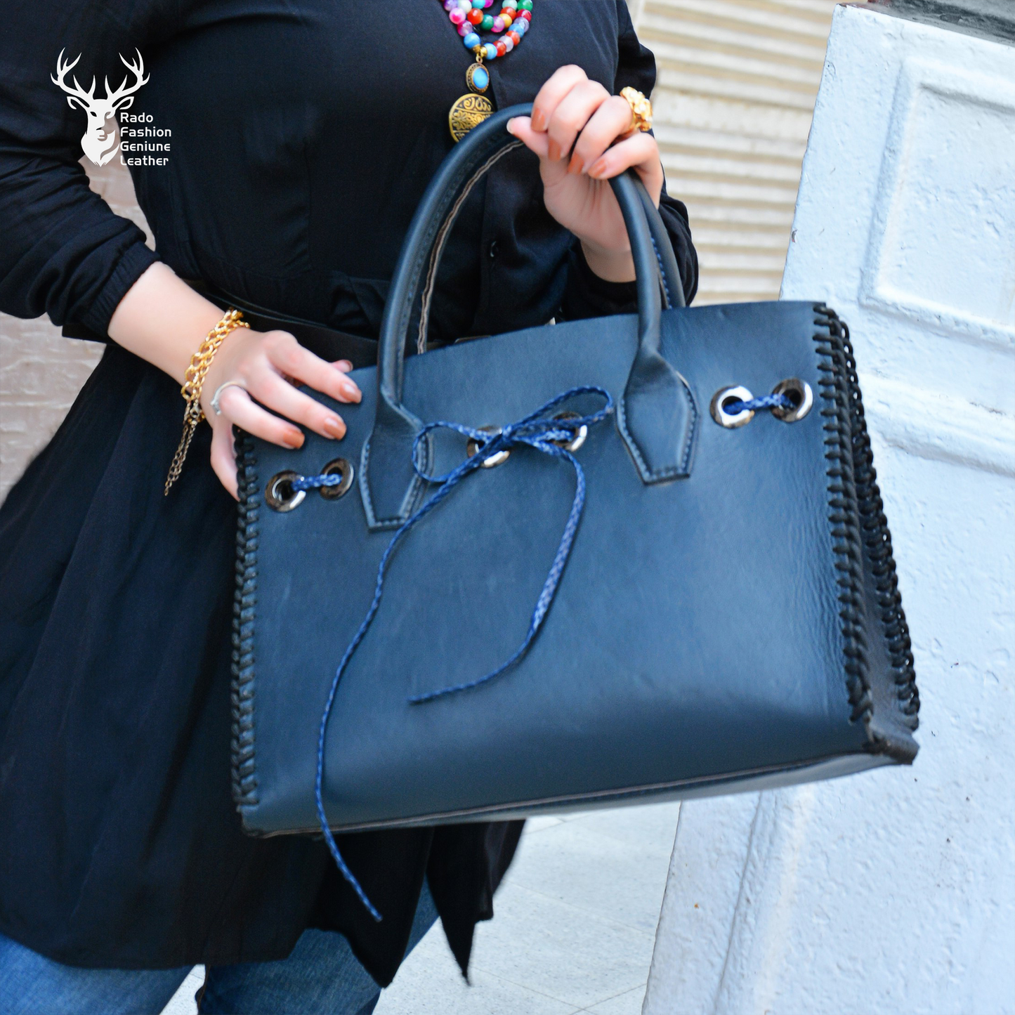 Bow tied deep blue bag with laced stitches